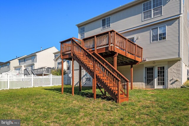 rear view of property featuring a lawn and a wooden deck