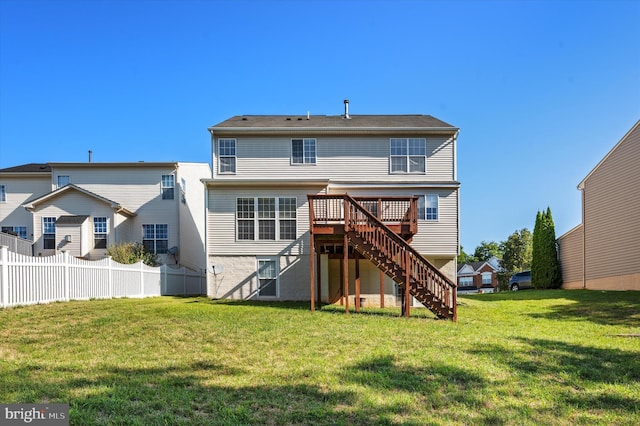 rear view of house with a deck, a yard, stairway, and fence