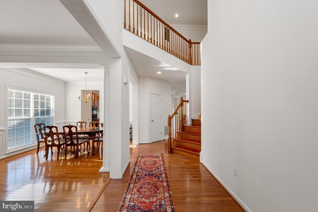 entryway featuring ornamental molding, an inviting chandelier, and wood-type flooring