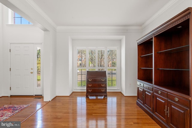 entrance foyer featuring baseboards, light wood-style flooring, and crown molding