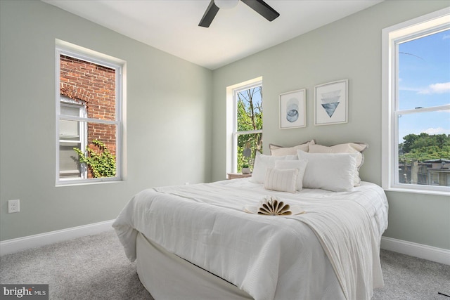 carpeted bedroom with ceiling fan and multiple windows