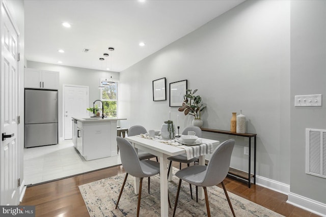 dining space with sink and light hardwood / wood-style flooring