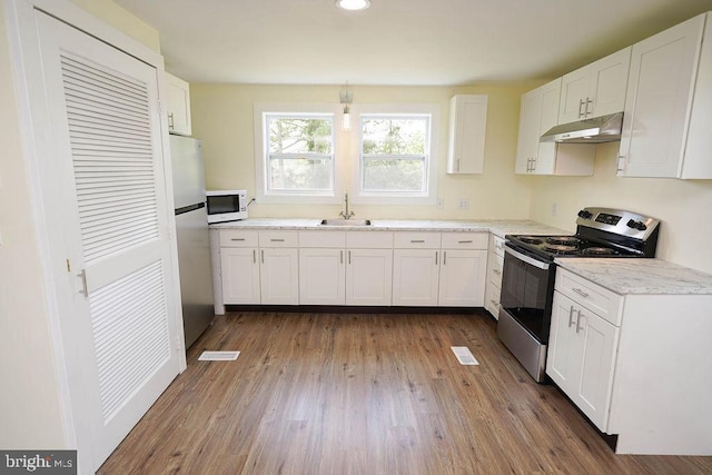 kitchen with hardwood / wood-style flooring, sink, white cabinetry, and stainless steel appliances