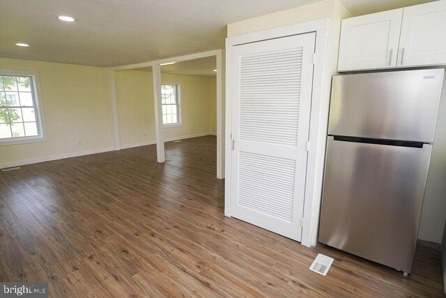 interior space featuring white cabinetry, hardwood / wood-style flooring, and stainless steel refrigerator