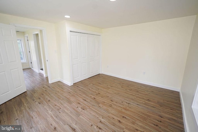 unfurnished bedroom with a closet and wood-type flooring