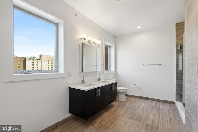 bathroom featuring toilet, plenty of natural light, and vanity