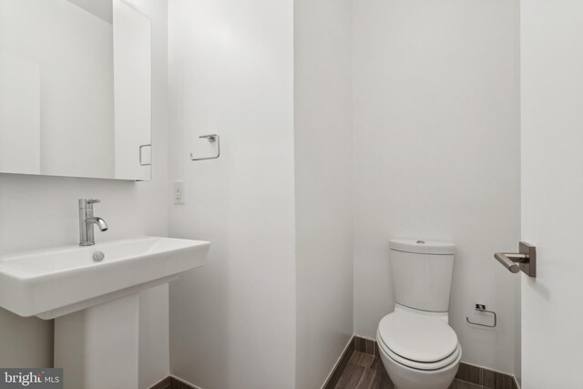 bathroom with toilet and hardwood / wood-style flooring