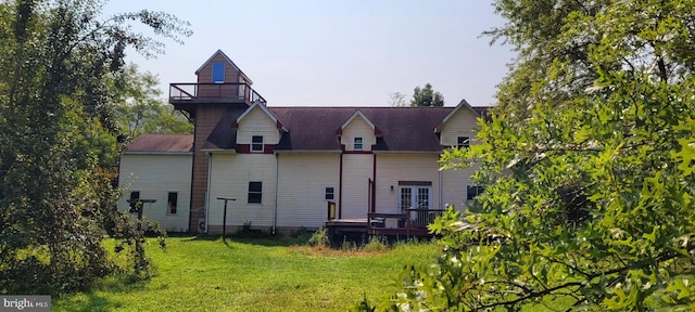 back of property featuring a lawn, a balcony, a deck, and french doors