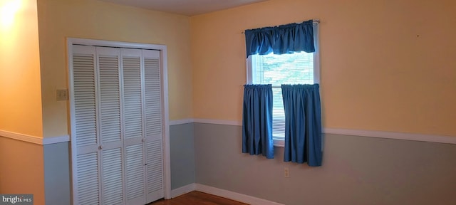 unfurnished bedroom with a closet and hardwood / wood-style floors