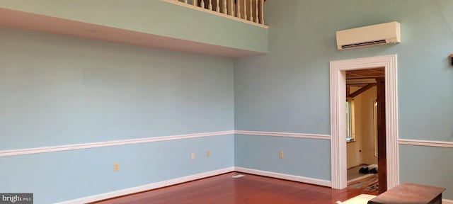 spare room with hardwood / wood-style flooring and a wall unit AC