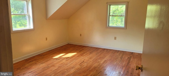 additional living space featuring lofted ceiling and light wood-type flooring