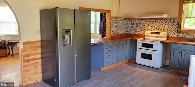 kitchen with wood counters, backsplash, white range with electric cooktop, stainless steel fridge, and dark hardwood / wood-style flooring