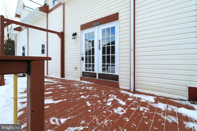 snow covered deck featuring french doors