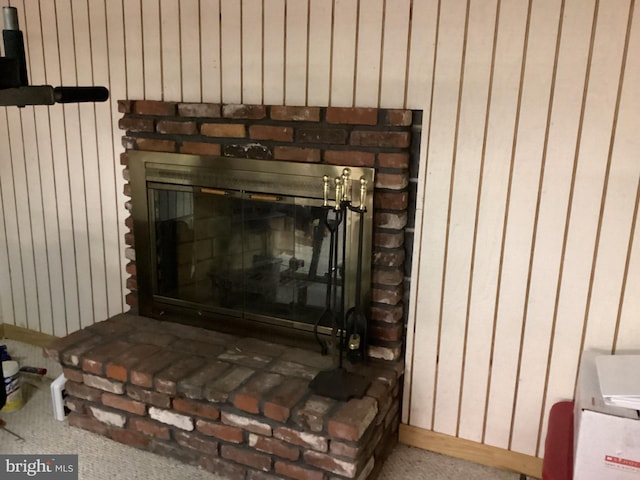 interior details with wood walls and a fireplace