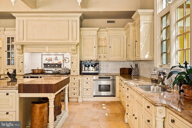 kitchen with a breakfast bar, a spacious island, decorative light fixtures, a towering ceiling, and light tile patterned floors