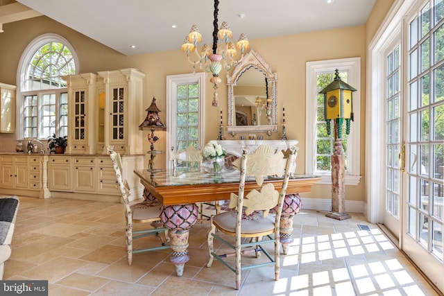 tiled dining room with a wealth of natural light and an inviting chandelier