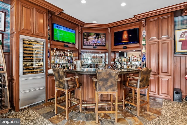 bar with stone countertops and dark tile patterned floors