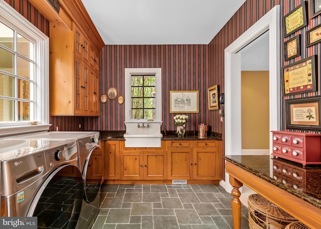 interior space featuring sink, washer and dryer, cabinets, and dark tile patterned floors