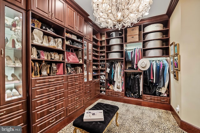 walk in closet featuring a chandelier