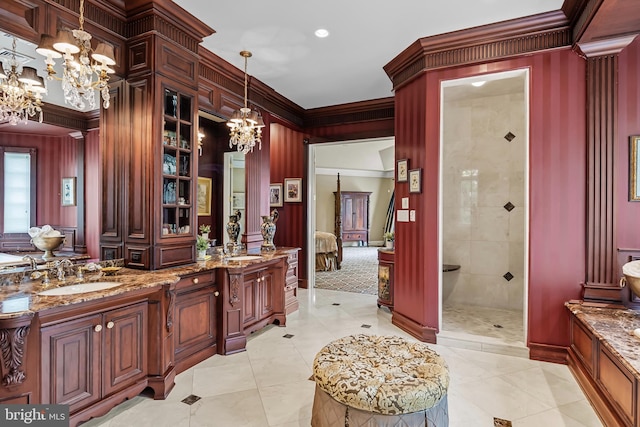 bathroom with a notable chandelier, ornamental molding, tiled shower, tile patterned flooring, and vanity