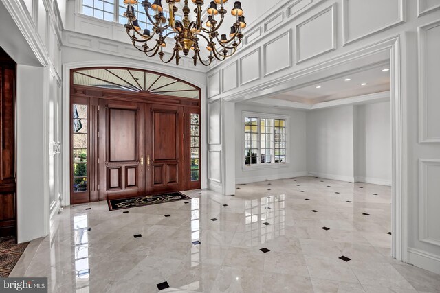 office area featuring ornamental molding, built in shelves, coffered ceiling, wooden walls, and a premium fireplace