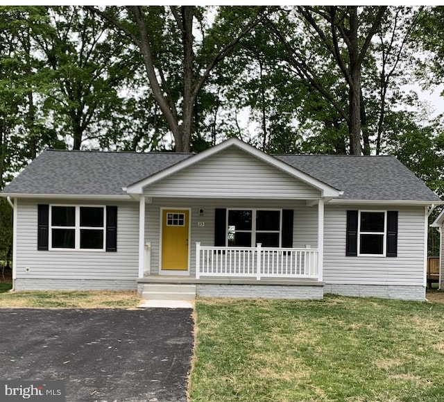 ranch-style house featuring a front yard and covered porch