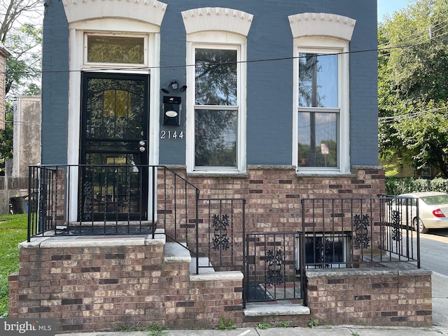 doorway to property featuring brick siding