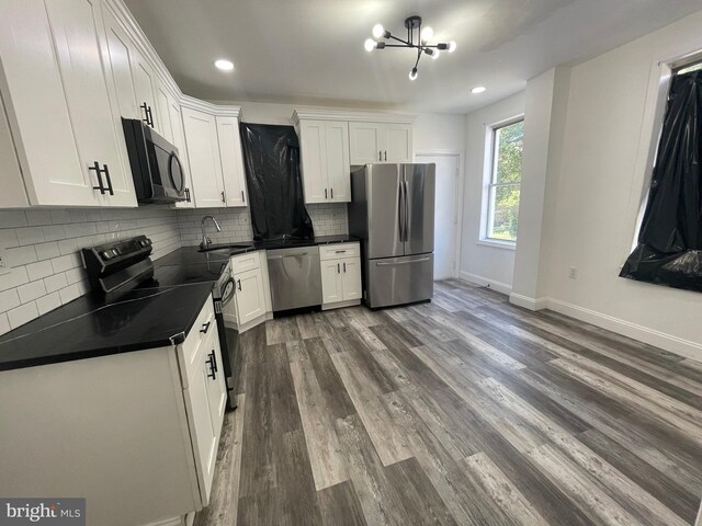 kitchen with appliances with stainless steel finishes, backsplash, sink, and white cabinets