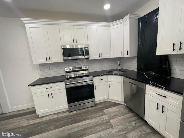 kitchen featuring stainless steel appliances, dark wood-style flooring, and white cabinets