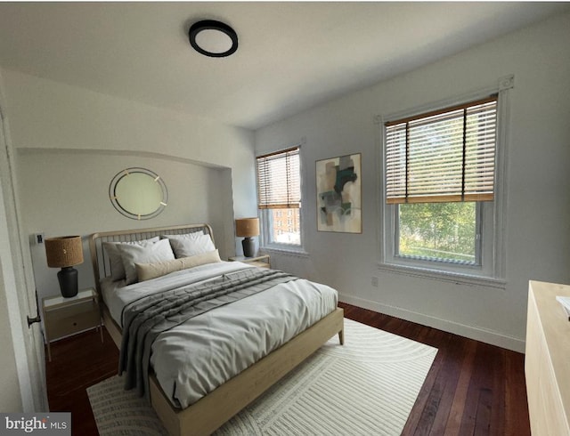 bedroom featuring dark wood finished floors and baseboards