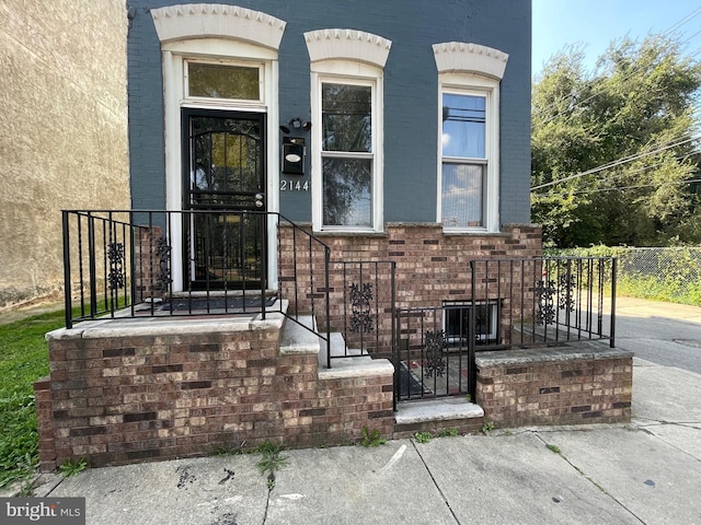 doorway to property with brick siding