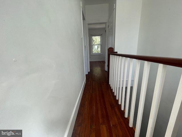 hallway featuring wood finished floors and baseboards