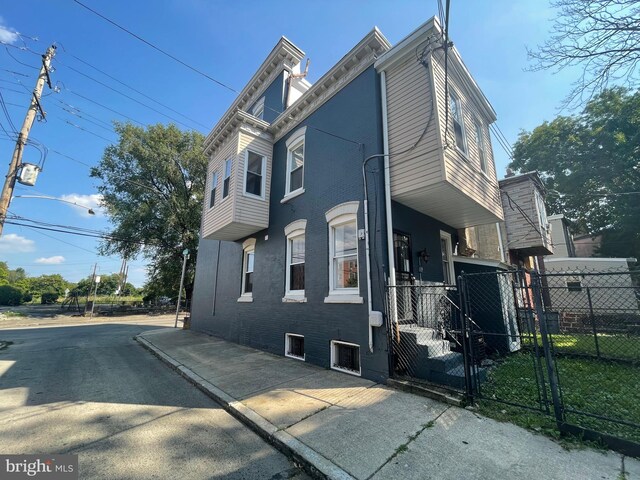 view of front of house with fence and brick siding