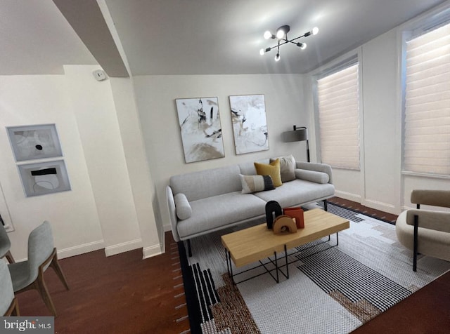 living area with a notable chandelier, baseboards, and wood finished floors