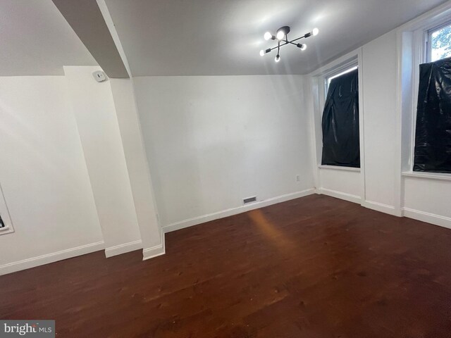 basement featuring dark hardwood / wood-style floors and a chandelier