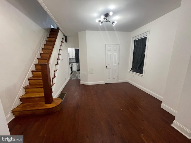 interior space with baseboards, visible vents, stairway, dark wood-type flooring, and a notable chandelier