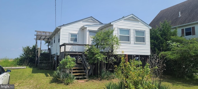 view of front facade featuring a wooden deck and a front yard