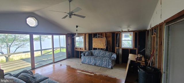 living room with vaulted ceiling, a water view, and a healthy amount of sunlight