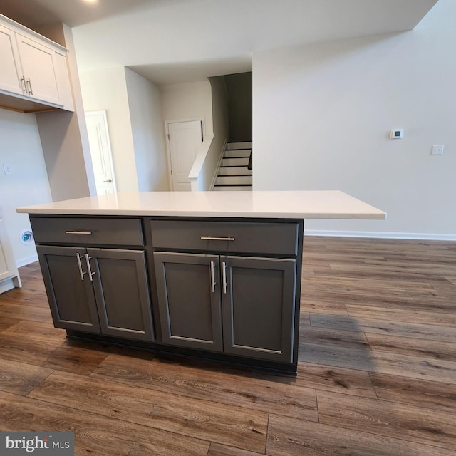 kitchen with white cabinetry, a kitchen island, and dark hardwood / wood-style floors