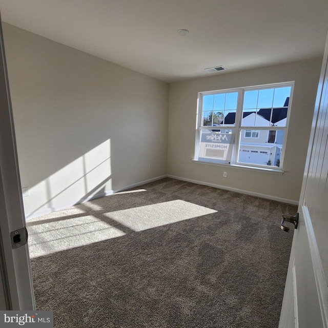 empty room featuring dark carpet