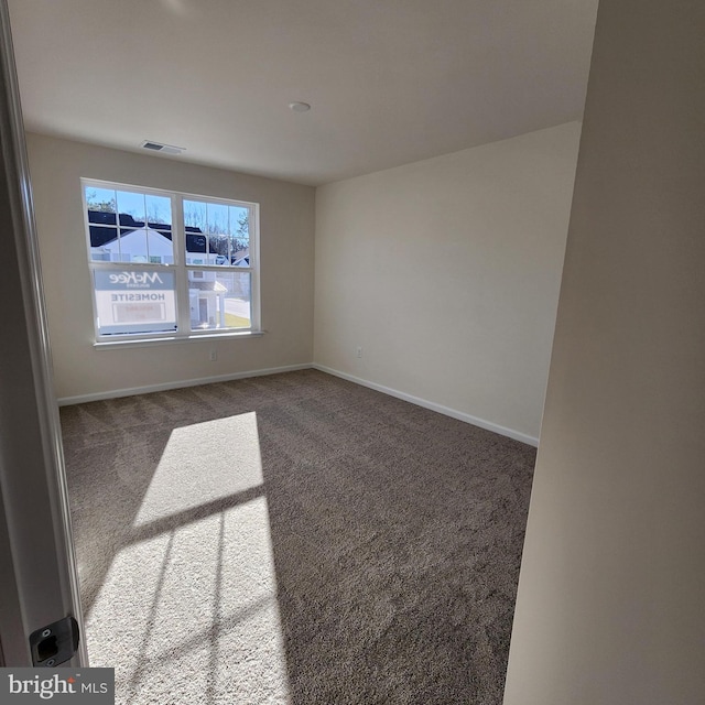 empty room featuring dark carpet