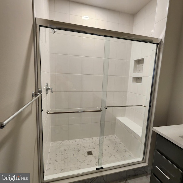 bathroom featuring vanity and a shower with shower door