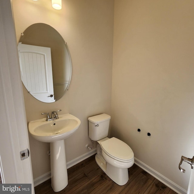 bathroom with hardwood / wood-style floors, toilet, and sink