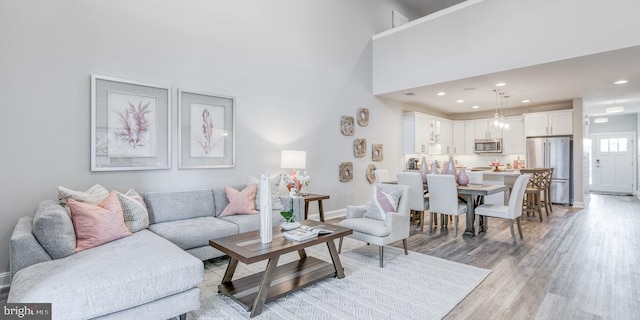 living room with a high ceiling and light hardwood / wood-style flooring