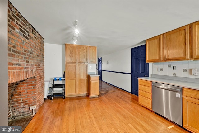 kitchen featuring light wood-type flooring, backsplash, dishwasher, and brick wall