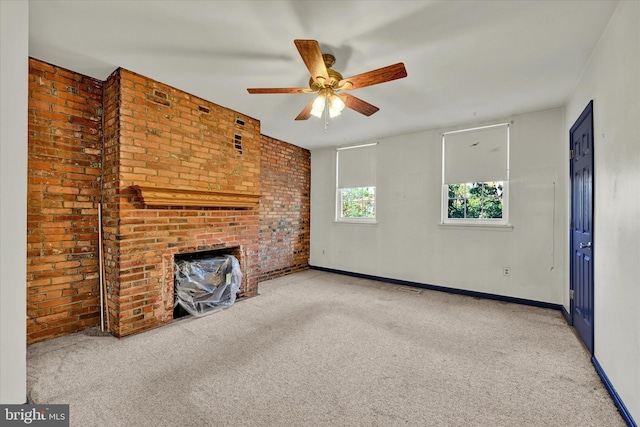 unfurnished living room featuring brick wall, ceiling fan, and light colored carpet