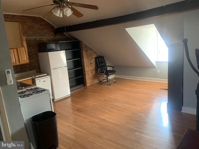 kitchen with vaulted ceiling with beams, light hardwood / wood-style flooring, and brick wall