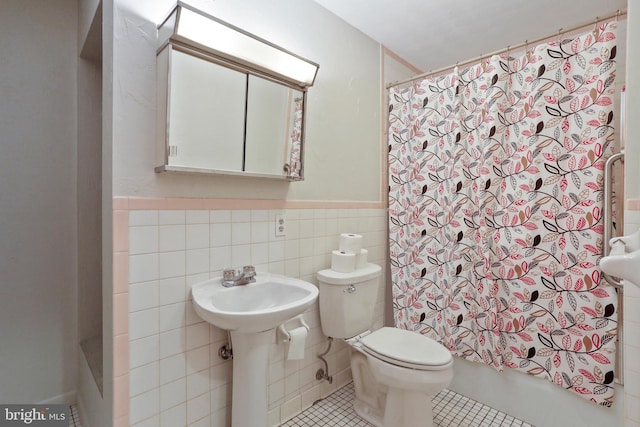 bathroom featuring shower / tub combo with curtain, tile patterned floors, toilet, and tile walls