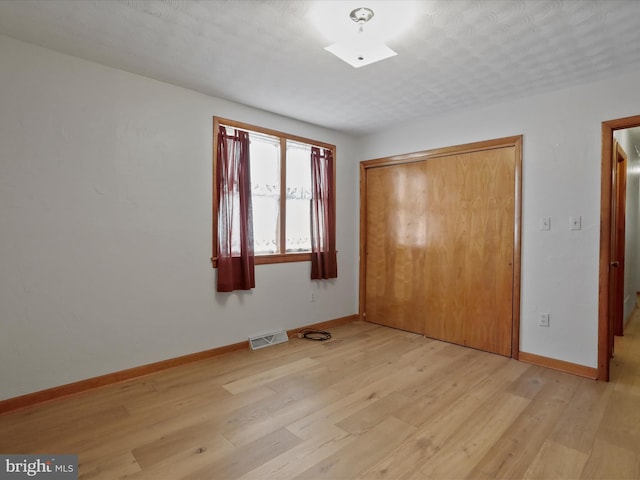 unfurnished bedroom featuring a closet and light hardwood / wood-style flooring