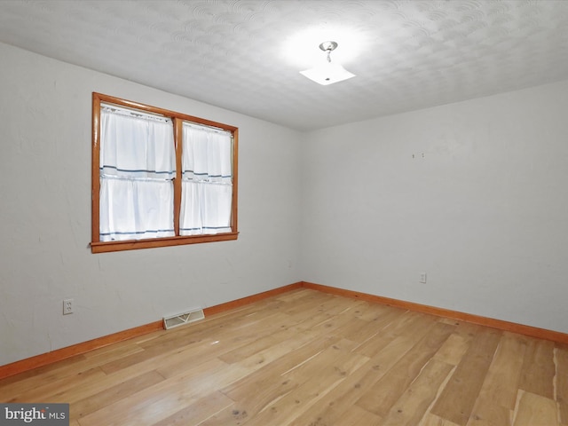 unfurnished room with light wood-type flooring